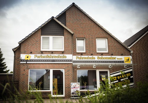 Gebäude der Fahrschule Schomaker-Behrens am Splitting rechts in Papenburg mit den gelben Schildern „Ferienfahrschule“ und „Fahrschule Schomaker“